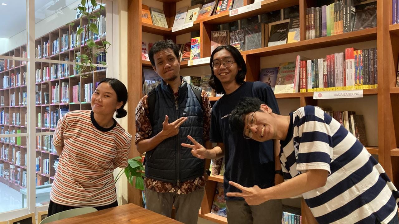 Empat pengurus API tertawa bersama di antara rak-rak buku sebuah perpustakaan di Bandung.